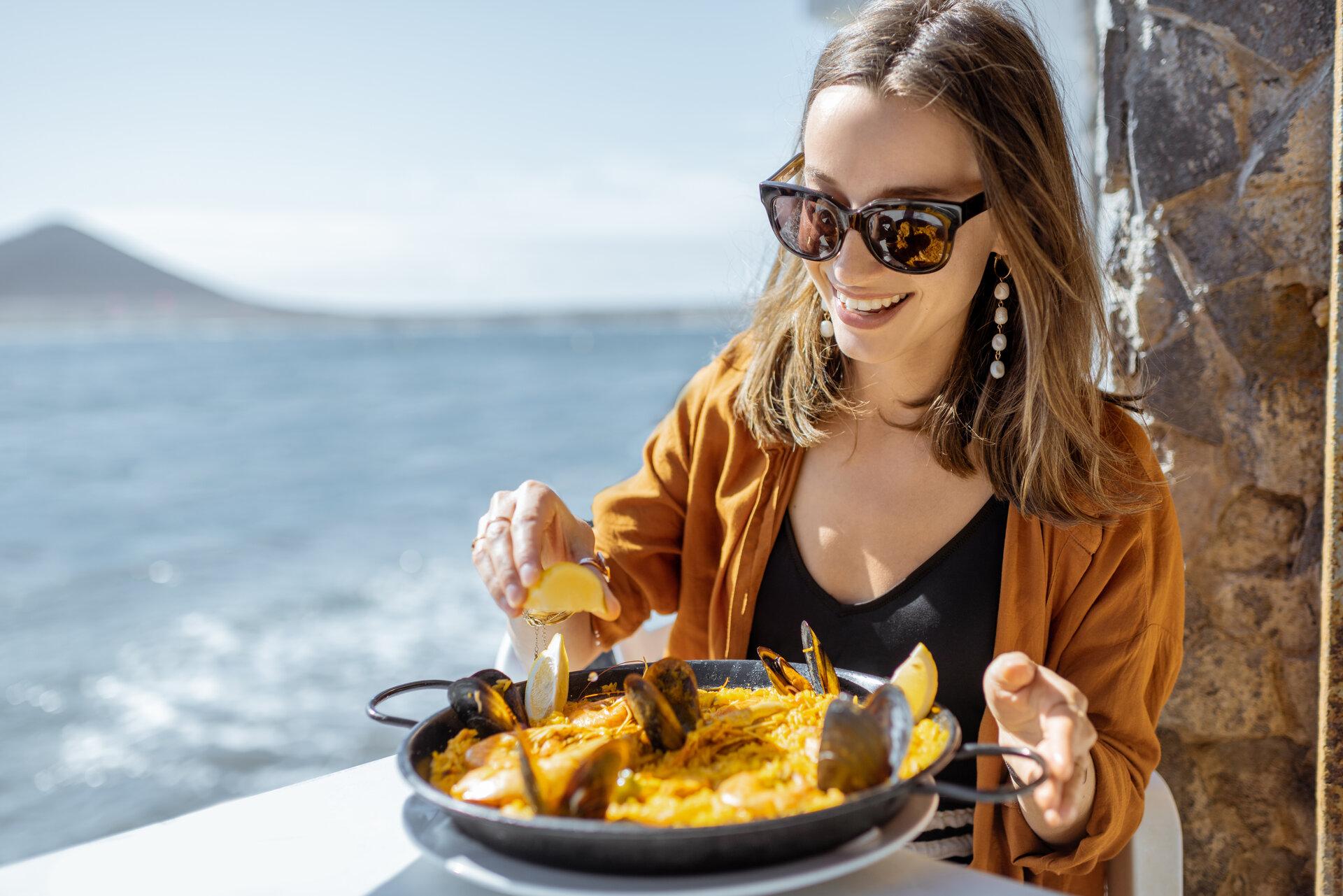 Woman eating paella, traditional spanish dish, 